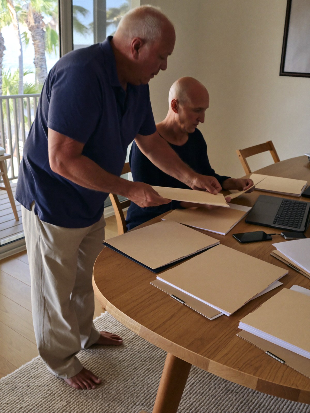Couple preparing property-sale records in a bright coastal apartment