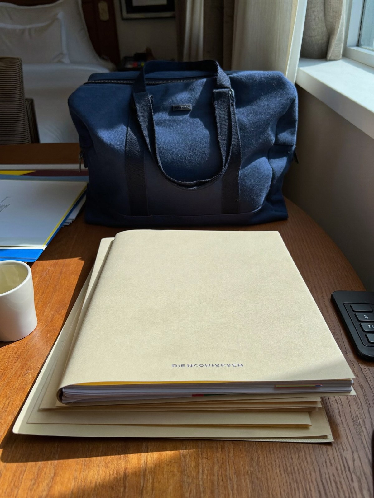 Travel bag and organized folders on a quiet desk