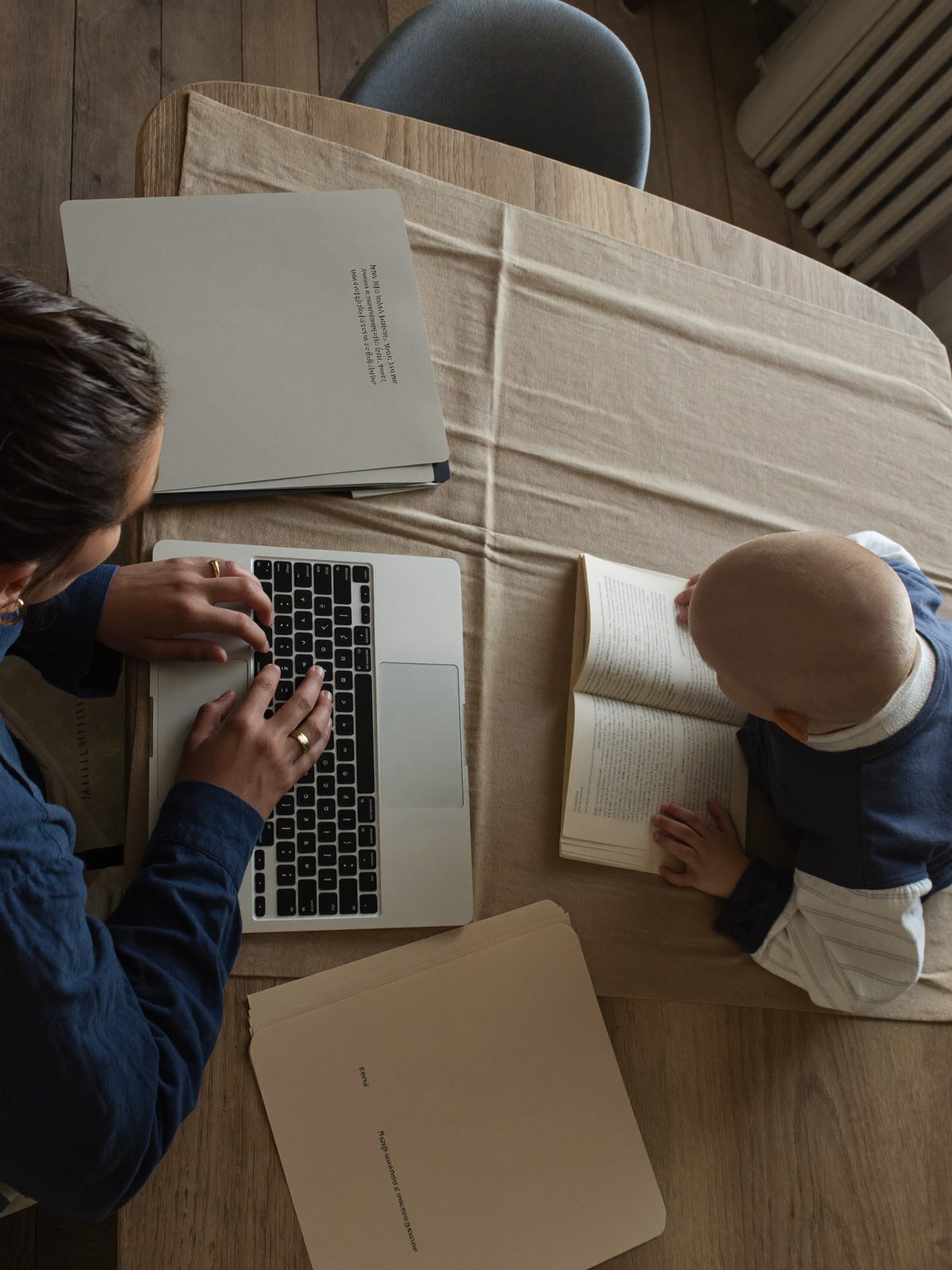Parent organizing family records at a kitchen table